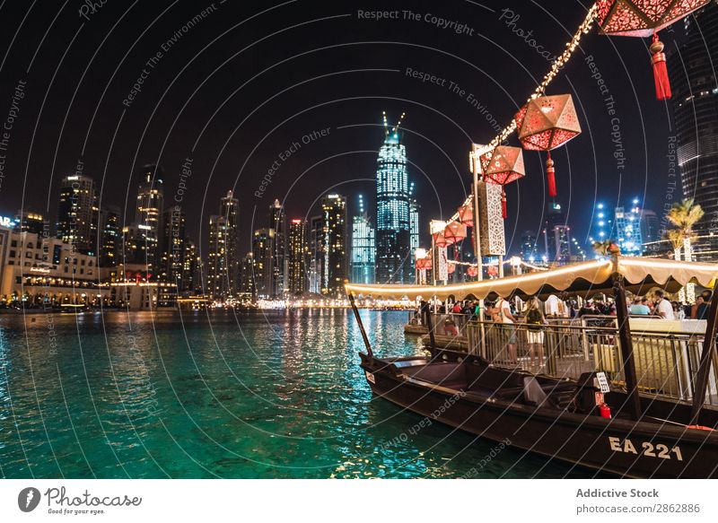 Boat and embankment in night metropolis Watercraft Jetty crowd High-rise City Illuminate Night Dubai Architecture Town Skyline Downtown Modern Vacation & Travel