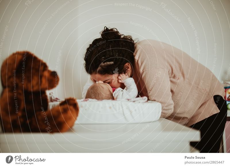 Woman Kissing Toddler Daughter Lying On Table At Home maternity Mother motherhood Family & Relations Baby Love parenthood people Happy Parents Beautiful care