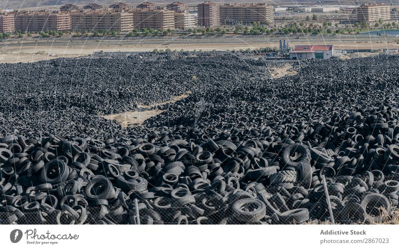 Heap of old tires between field near city Tire Field City huge Car Accumulation Old Town Sky Beautiful weather Clouds Meadow Rubber Black Stack Second-hand