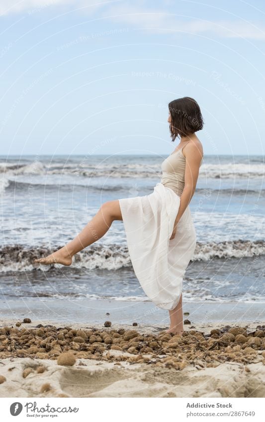 Charming young woman on shore near water Woman Water Coast Ocean Beach Lady waving Posture Youth (Young adults) Thin Attractive Vacation & Travel Passion