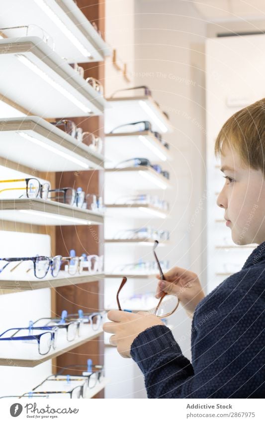 Young boy trying on glasses Boy (child) Child Eyes eyewear Fashion Person wearing glasses Lens ophtalmologist Optician optometrist optometry Looking Sunglasses