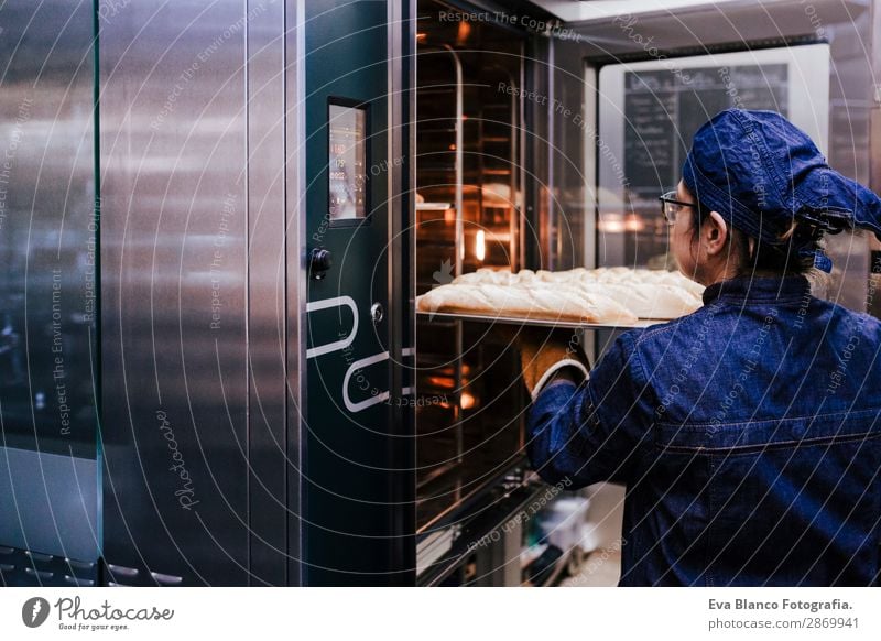 woman holding rack of rolls in a bakery. Bread Happy Kitchen Restaurant School Work and employment Profession Camera Feminine Woman Adults 1 Human being