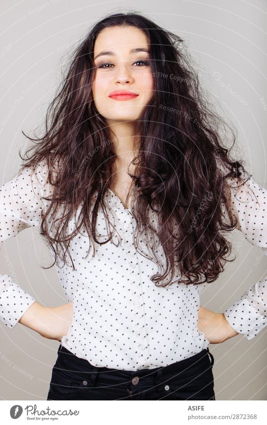 Beautiful and funny brunette girl in polka dots shirt with tousled hair and hands on hips Joy Happy Human being Woman Adults Fashion Shirt Pants Brunette