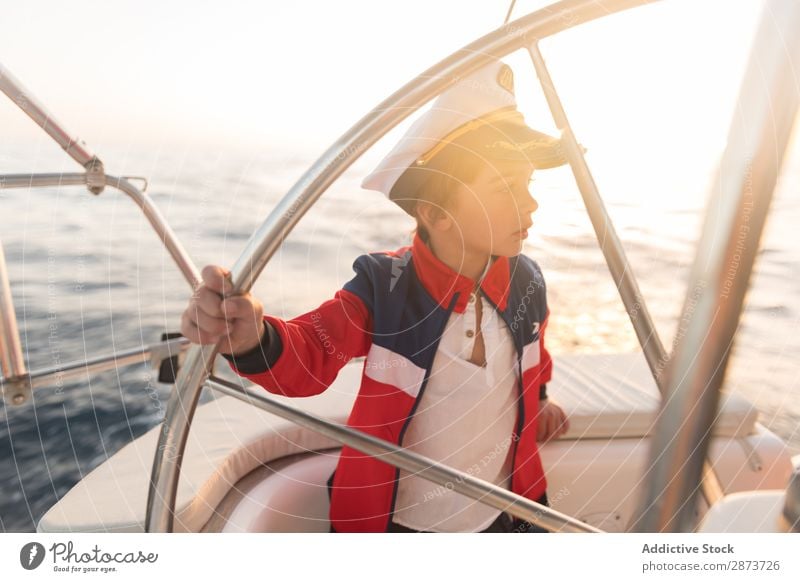 Smiling girl holding steering wheel on yacht on water Girl Yacht Water Steering wheel Captain Hat Ocean Child Floating Beautiful weather Watercraft Expensive