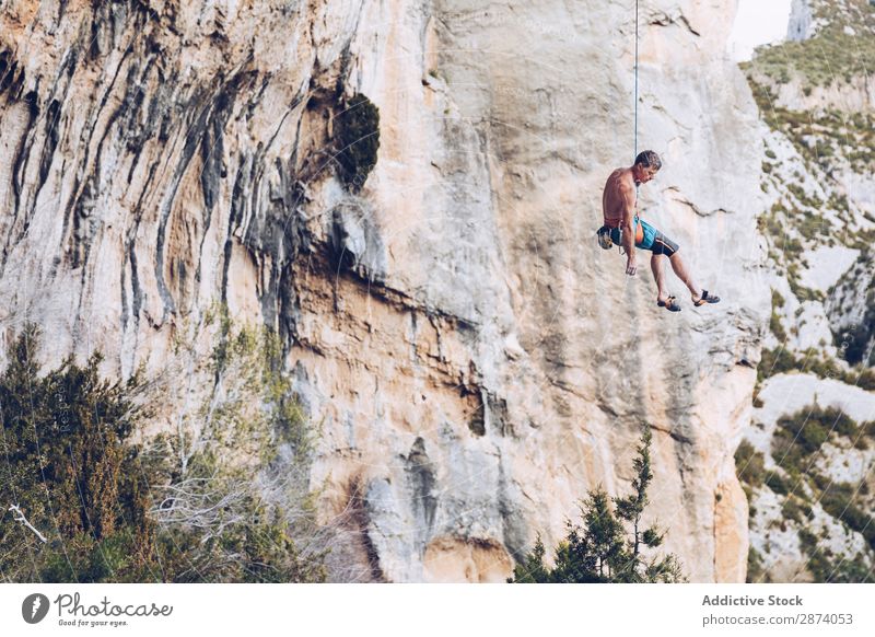 Anonymous climber handing on cliff Climber Cliff Hanging Rope Extreme Sky Blue Mountain Rock Sports challenge Action Success Power Height Adventure Risk belay