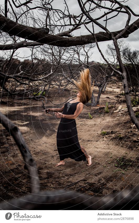 Woman posing on ground near dry trees Ballerina Posture Ground Tree Mysterious reborn murk Wear Landing Wood Youth (Young adults) Black Dry Performance Elegant