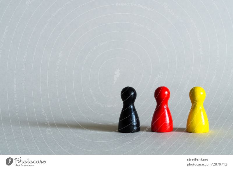 Three game pieces in black, red, yellow stand in a row Group Toys Wood Sign Yellow Red Black Together Society Politics and state Germany German Flag German flag