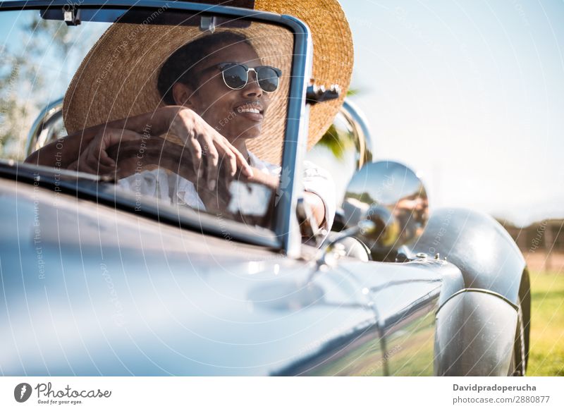 Black woman driving a vintage convertible car Woman Car Driving Ethnic Convertible Street Luxury Looking away Transport Happy Classic 60's Beautiful Vintage