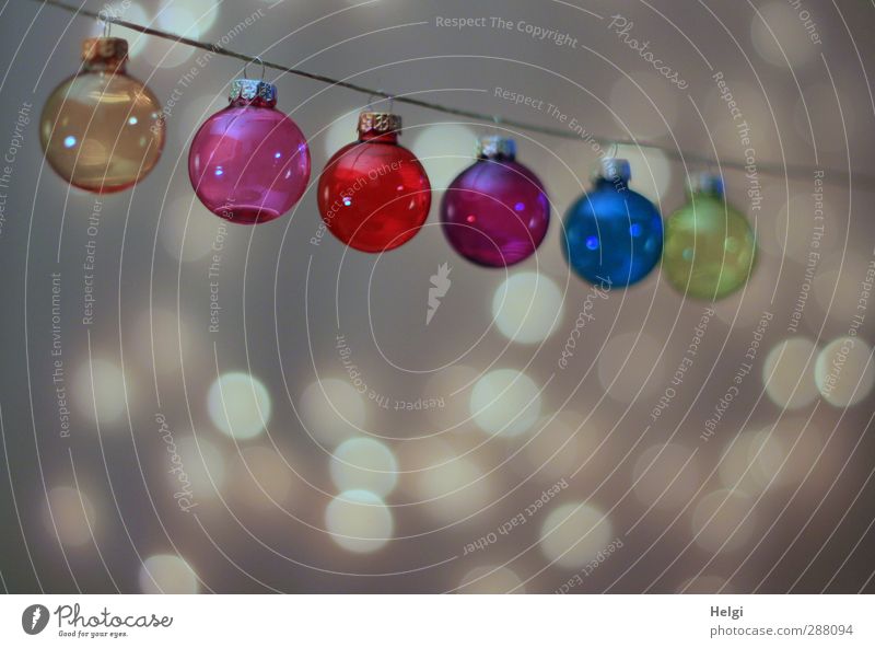 colourful glass Christmas tree balls hang on a string, with light points in the background Feasts & Celebrations Christmas & Advent Decoration Glitter Ball