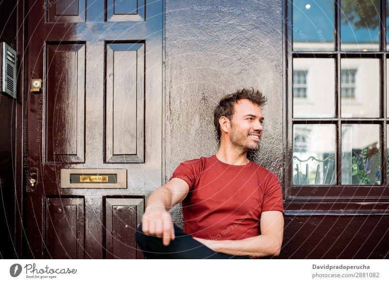 Man sitting in a bench on a beautiful maroon background Cheerful Caucasian Building Youth (Young adults) Happy Architecture Vintage Smiling Notting Hill decor