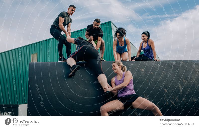 Participants in obstacle course helping to climb drum Lifestyle Joy Happy Sports Climbing Mountaineering Human being Woman Adults Man Group Smiling Authentic