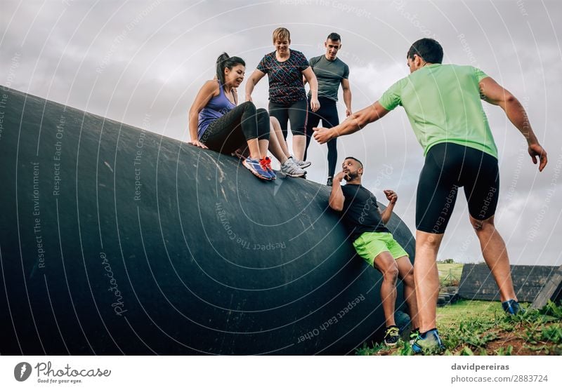 Group in obstacle course going down drum Lifestyle Sports Human being Woman Adults Man Authentic Strong Black Effort Competition Teamwork obstacle course race