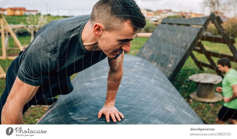 Male participant in obstacle course climbing drum Lifestyle Sports Climbing Mountaineering Human being Man Adults Authentic Strong Power Effort young