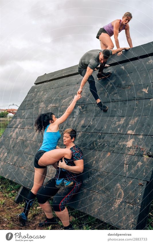 Group in obstacle course climbing pyramid Sports Climbing Mountaineering Human being Woman Adults Man Observe Authentic Strong Effort Competition Teamwork