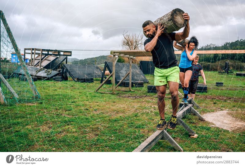 Participants in obstacle course carrying trunks Contentment Sports Human being Woman Adults Man Group Carrying Authentic Strong Black Effort Competition