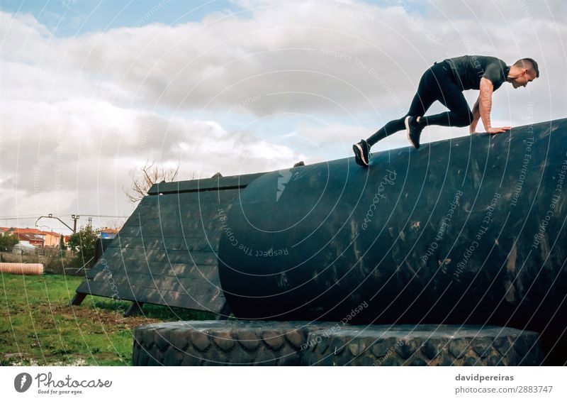 Man in obstacle course climbing drum Lifestyle Sports Climbing Mountaineering Human being Adults Authentic Strong Effort young empowerment obstacle course race