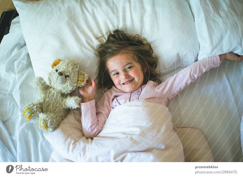 Little girl lying in a bed with teddy bear at the morning. Happy mornings. Bedtime. Weekend mornings Beautiful Playing Child Human being Woman Adults Toys