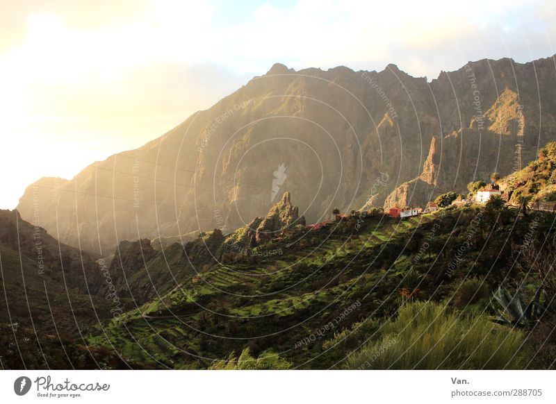 sunray lamp Nature Landscape Sky Clouds Beautiful weather Grass Bushes Field Rock Mountain Peak Village House (Residential Structure) Bright Warmth Green