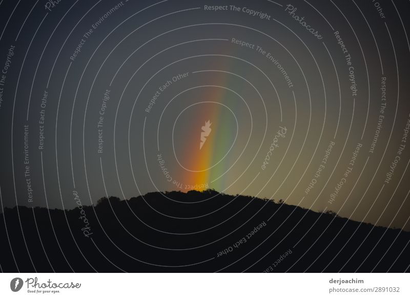 The sky is colourful with the rays of the rainbow. It shines on a wooded hill with forest. Relaxation Calm Summer Environment Nature Landscape Night sky