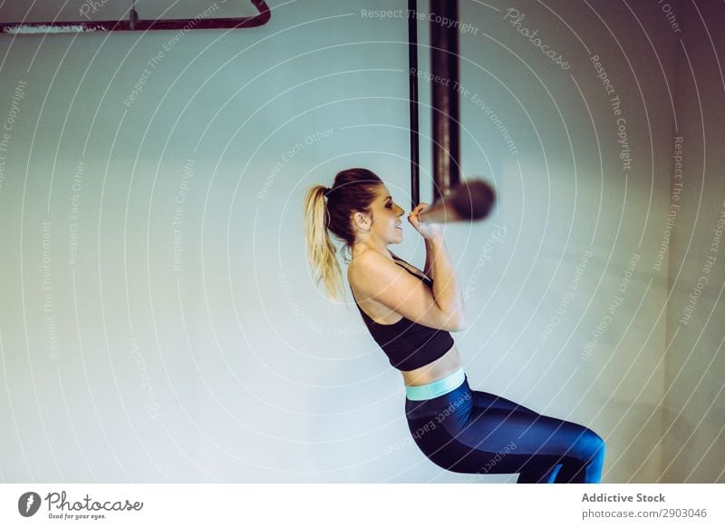 Young woman doing pull ups in gym Woman Bar Gymnasium Looking up workout Practice Athlete Sports Strong Fitness Healthy Action physical Muscular Sportswear