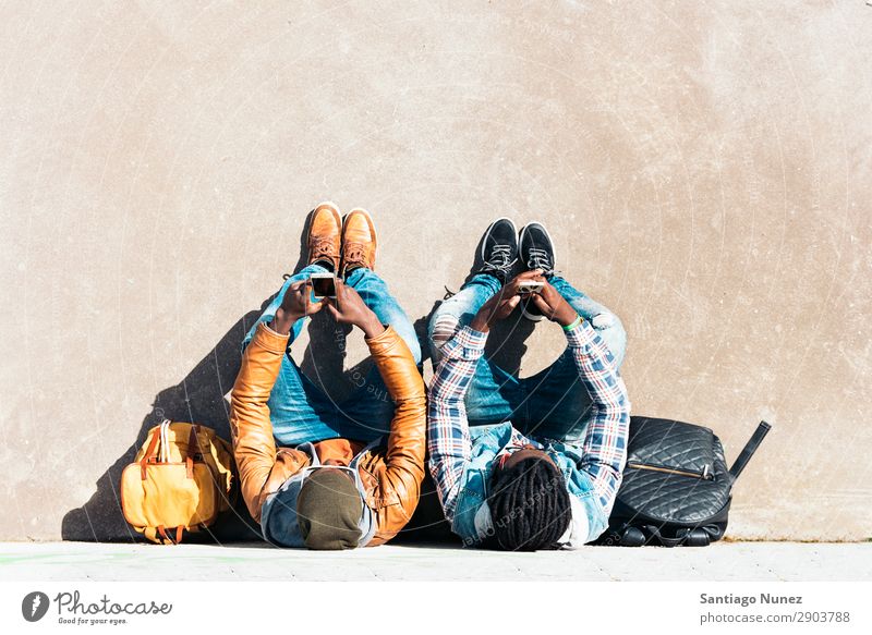 Two black race friends having fun. Friendship Telephone Cellphone Town African Black American Mobile Youth (Young adults) Man Laughter PDA Technology