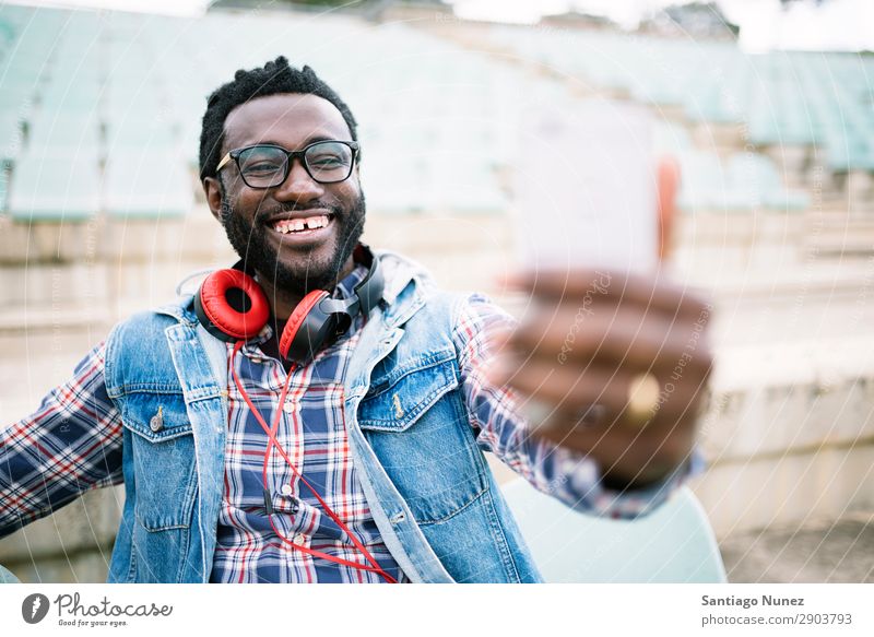 American man using mobile in the street. Man Telephone Cellphone Town African Black Mobile Youth (Young adults) Laughter PDA Technology Human being Happy