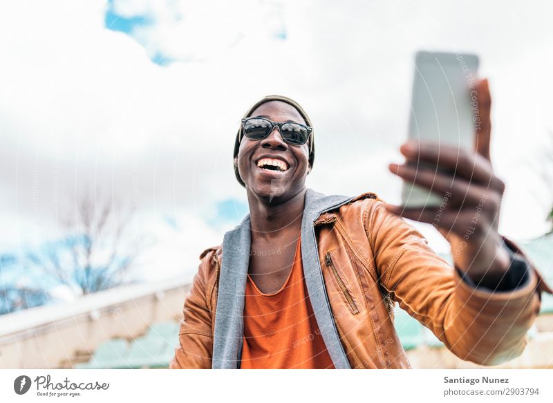 American man using mobile in the street. Man Telephone Cellphone Town African Black Mobile Youth (Young adults) Laughter PDA Technology Human being Happy