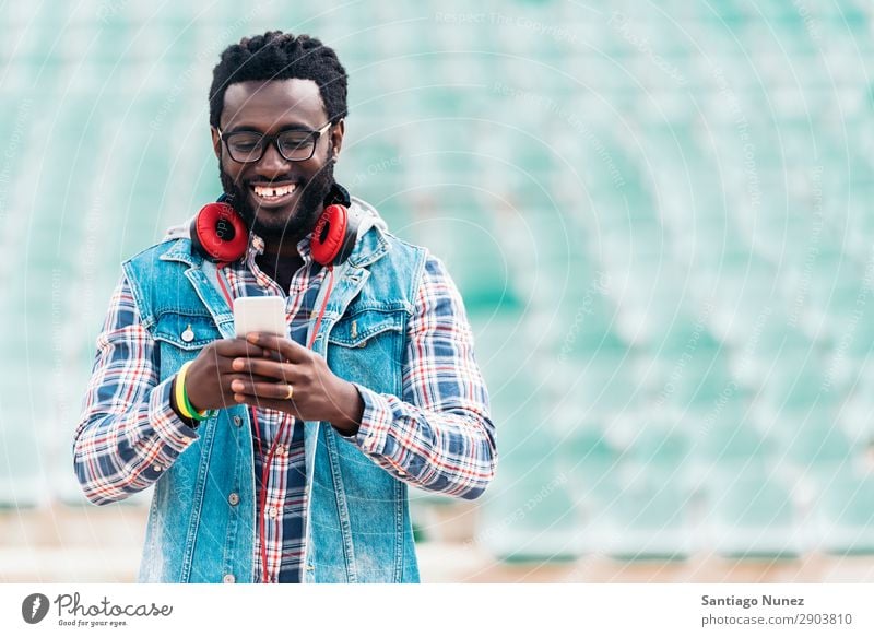 American man using mobile in the street. Man Telephone Cellphone Town African Black Mobile Youth (Young adults) Laughter PDA Technology Human being Happy