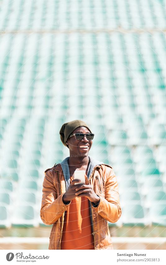 American man using mobile in the street. Man Telephone Cellphone Town African Black Mobile Youth (Young adults) Laughter PDA Technology Human being Happy