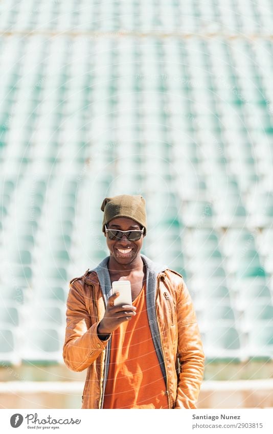 American man using mobile in the street. Man Telephone Cellphone Town African Black Mobile Youth (Young adults) Laughter PDA Technology Human being Happy