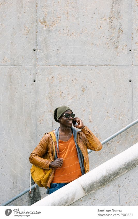 American man using mobile in the street. Man Telephone Cellphone Town African Black Mobile Youth (Young adults) Laughter PDA Technology Human being Happy