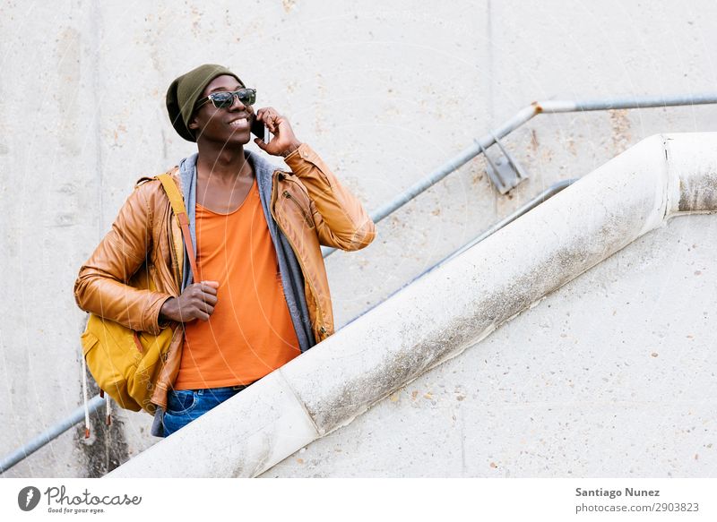 American man using mobile in the street. Man Telephone Cellphone Town African Black Mobile Youth (Young adults) Laughter PDA Technology Human being Happy