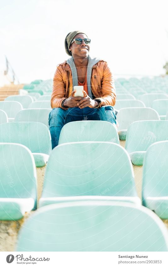 American man using mobile in the street. Man Telephone Cellphone Town African Black Mobile Youth (Young adults) Laughter PDA Technology Human being Happy