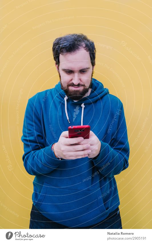 A young man looks attentively at his cell phone Lifestyle Happy Beautiful Music Telephone PDA Screen Camera Technology Human being Boy (child) Man Adults