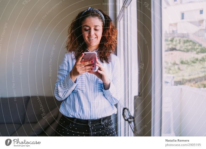 Young woman leans on the window looking at the mobile Happy Profession Workplace Office Business Company Telephone Cellphone PDA Human being Woman Adults