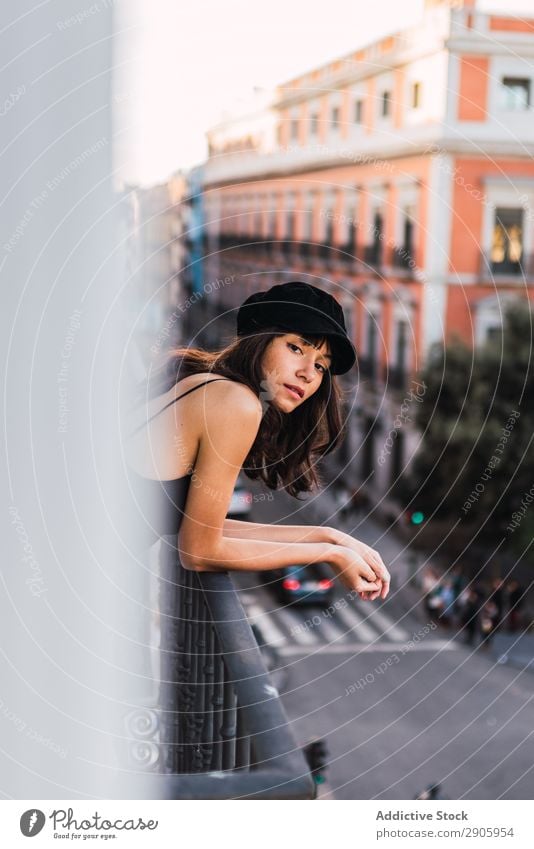 Attractive woman in cap on balcony in evening Woman Balcony Cap Street City Youth (Young adults) Home Evening Thin Building Charming Town