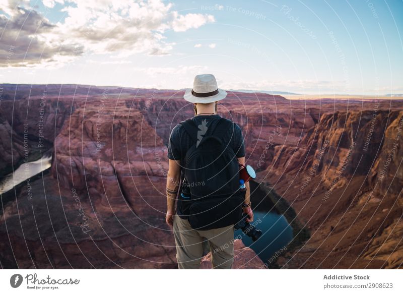 Bearded traveler holding camera on canyon Man photo camera River Canyon Vacation & Travel West Coast USA Sky Cliff Adventure Nature Hiking trekking Flow Stream