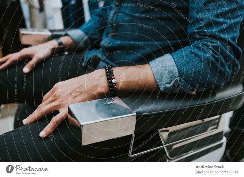 Man sitting in chair in salon Chair Sit Style Youth (Young adults) Bracelet Hand Hairdresser Considerate Barber shop Hair and hairstyles Fashion Masculine