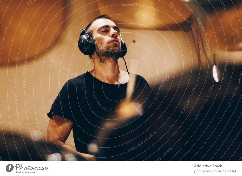 Man with headphones playing on drums Headphones Drum Playing Positive handsome Studio shot Music Professional Youth (Young adults) Drummer Equipment device