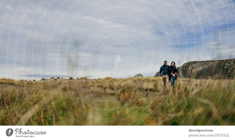 Young couple embraced walking near the coast Lifestyle Happy Beautiful Calm Leisure and hobbies Vacation & Travel Winter To talk Human being Woman Adults Man