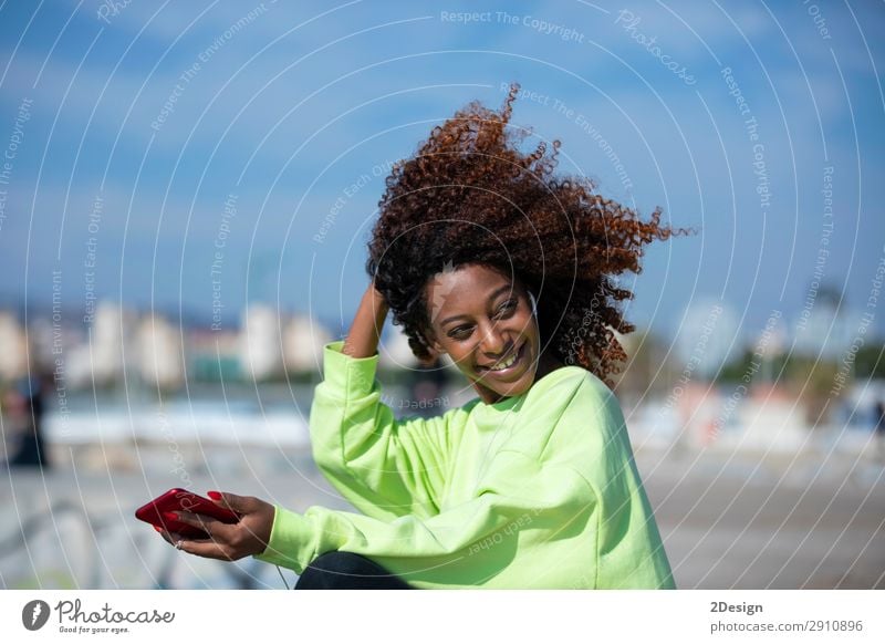 Side view of a young curly afro woman sitting on breakwater Lifestyle Style Beautiful Hair and hairstyles Ocean Music Telephone PDA Human being Feminine