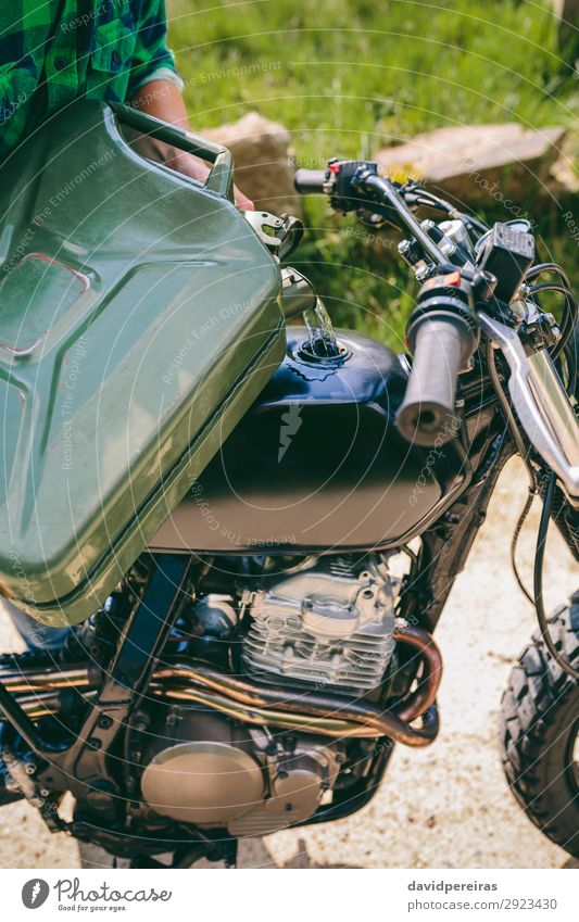 Man refilling the gas tank of a motorbike Lifestyle Beautiful Human being Adults Grass Transport Street Vehicle Motorcycle Authentic Retro petrol can Gasoline