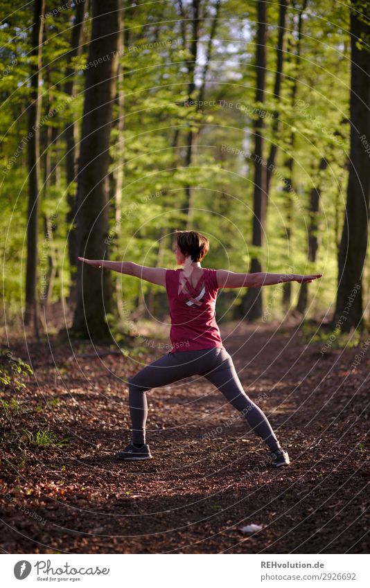 Woman doing yoga in the forest Central perspective Shallow depth of field blurriness Sunlight Silhouette Evening Day Exterior shot Colour photo