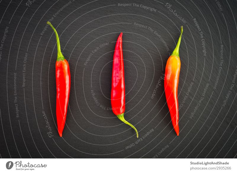 Red hot chili peppers on dark background Vegetable Herbs and spices Eating Vegetarian diet Healthy Eating Dark Simple Fresh Hot Cold Natural Green Black Colour