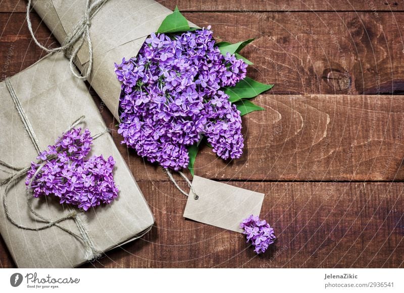 Gift and bouquet of lilacs on a wooden table Beautiful Summer Decoration Desk Table Feasts & Celebrations Valentine's Day Mother's Day Easter Christmas & Advent