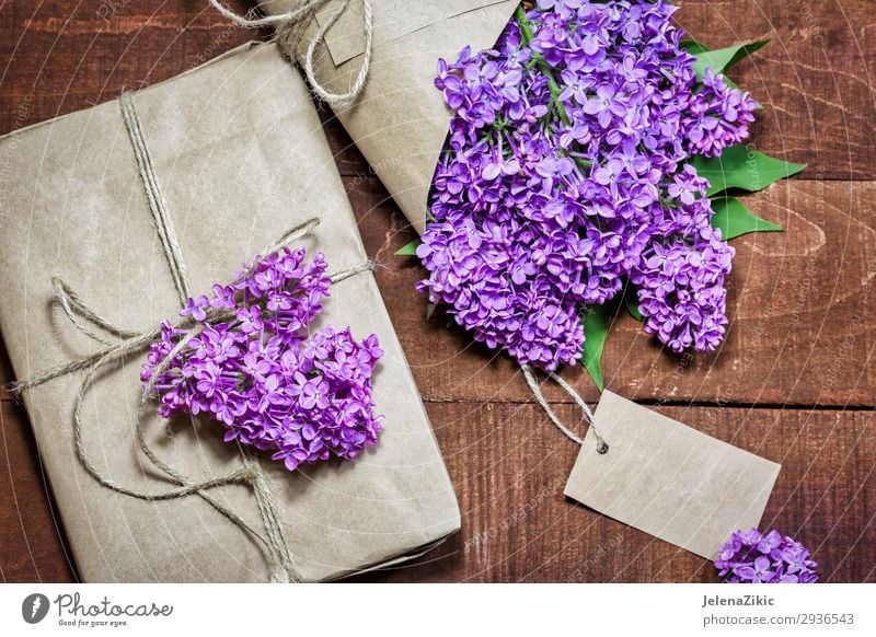 Gift and bouquet of lilacs on a wooden table Beautiful Summer Decoration Desk Table Feasts & Celebrations Mother's Day Easter Wedding Birthday Craft (trade)