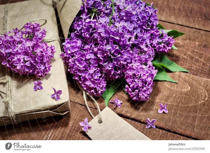 Gift and bouquet of lilacs on a wooden table Beautiful Summer Decoration Desk Table Feasts & Celebrations Valentine's Day Mother's Day Easter Christmas & Advent