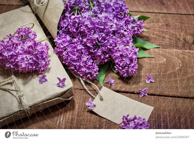 Gift and bouquet of lilacs on a wooden table Beautiful Summer Decoration Desk Table Feasts & Celebrations Valentine's Day Mother's Day Easter Christmas & Advent