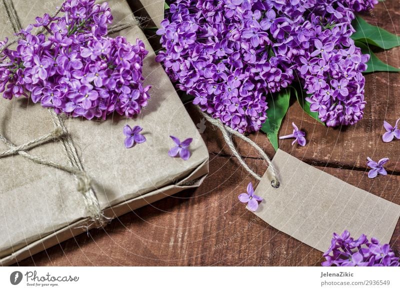 Gift and bouquet of lilacs on a wooden table Beautiful Summer Decoration Desk Table Feasts & Celebrations Valentine's Day Mother's Day Easter Christmas & Advent