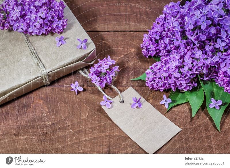 Gift and bouquet of lilacs on a wooden table Beautiful Summer Decoration Desk Table Feasts & Celebrations Valentine's Day Mother's Day Easter Christmas & Advent